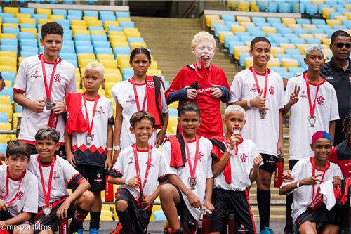 Alumnos de la red Escola Flamengo con medallas en el césped del Estadio Maracaná